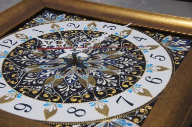 kahverengi kare el boyaması saatle bir mandala, siyah sayılar ve beyaz ok şeklinde geometrik desenli noktadan noktaya, tekniğinde kontur akrilik boyalar