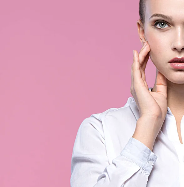 portrait of attractive caucasian woman isolated on pink studio shot lips face long hair head and shoulders looking at camera hands