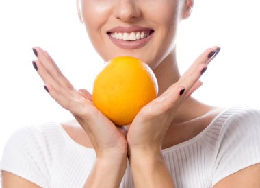 beyaz stüdyo kameraya bakarak portakal Narenciye meyve yüz makyaj ile ateş üzerinde izole çekici genç beyaz mutlu gülümseyen kadın güzellik portresi