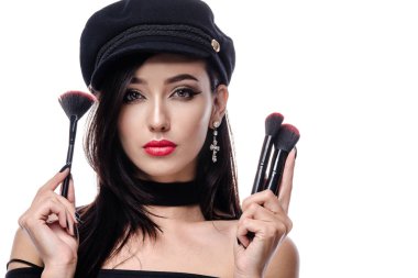 Kırmızı dudaklar yüzü uzun saç baş ve omuzlar kamera çivi makyaj fırçaları seyir çekici genç Kafkas kadın esmer beyaz studio izole Güzellik Portresi vurdu