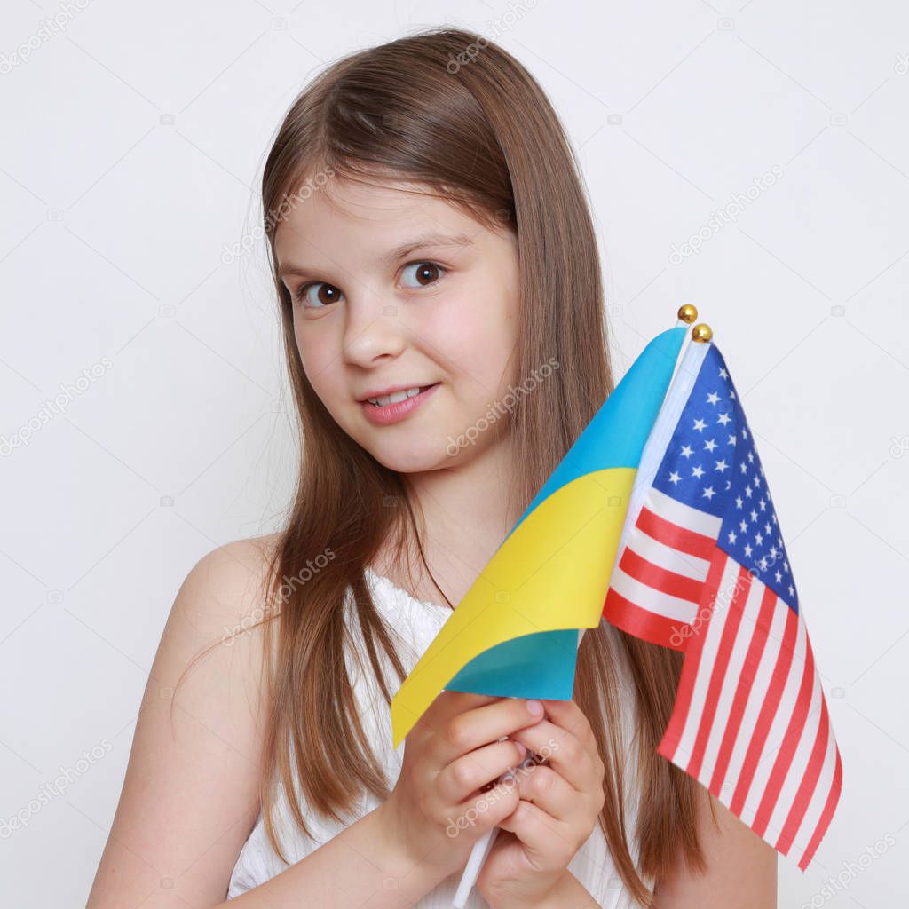 little girl holding Ukrainian and American flags