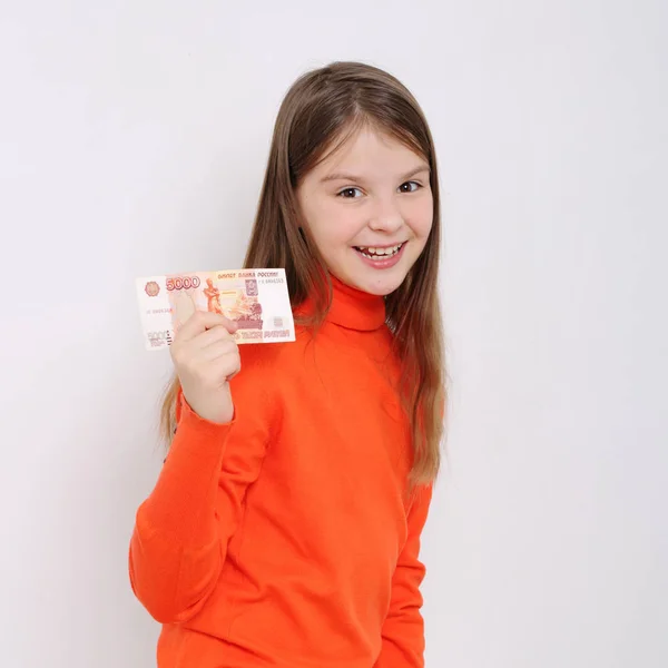 Teen girl holding 5000 rubles (five thousands roubles cash money of Russian Federation)