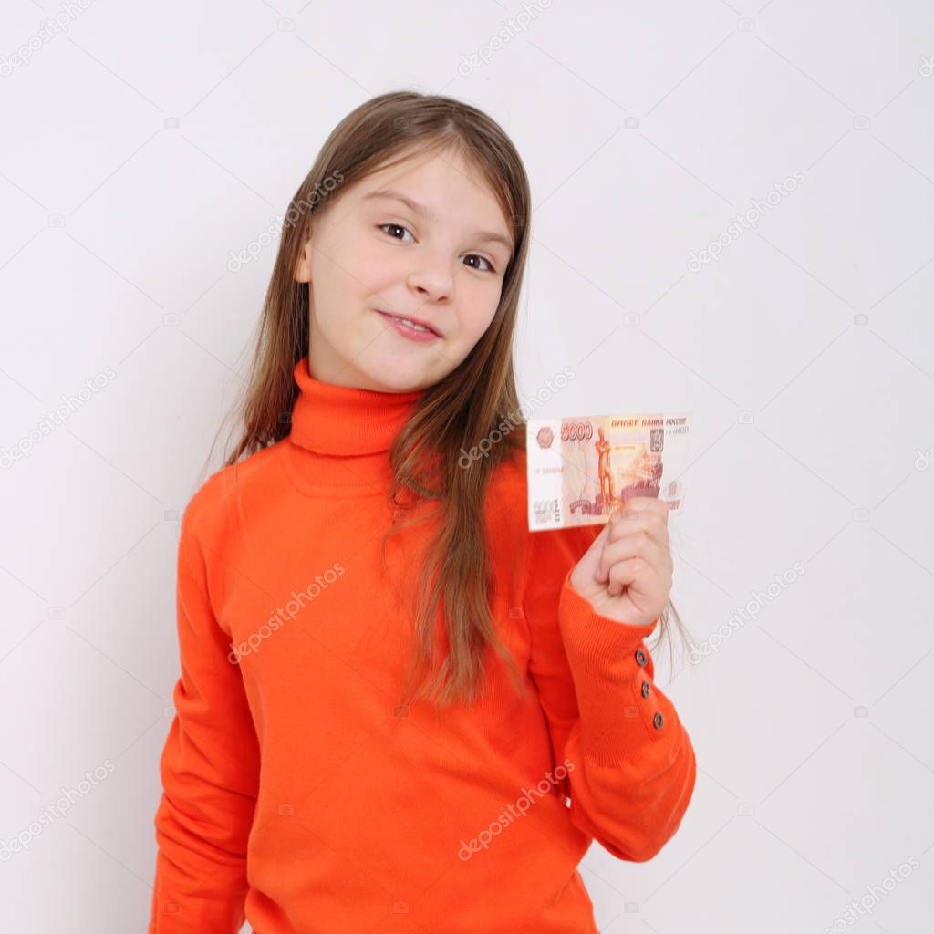 Teen girl holding 5000 rubles (five thousands roubles cash money of Russian Federation)