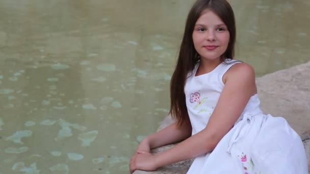 美丽的少女坐在城市喷泉在夏天 — 图库视频影像