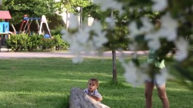 Küçük oğlan ve genç kız parkta oynuyorlar.