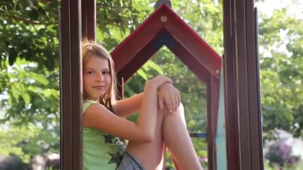 Genç Kız Dışarıda Oyun Bahçesinde Oturuyor — Stok video