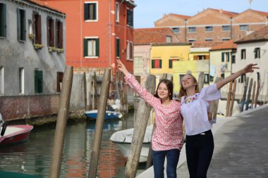 Genç kızlar Murano adasında turist olarak yürüyorlar, Veneto, İtalya