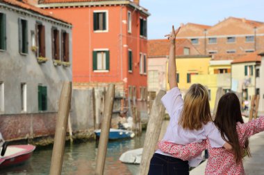 Genç kızlar Murano adasında turist olarak yürüyorlar, Veneto, İtalya