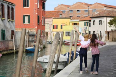 Genç kızlar Murano adasında turist olarak yürüyorlar, Veneto, İtalya
