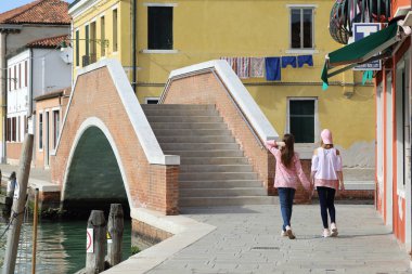 Genç kızlar Murano adasında turist olarak yürüyorlar, Veneto, İtalya