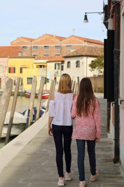 Genç kızlar Murano adasında turist olarak yürüyorlar, Veneto, İtalya