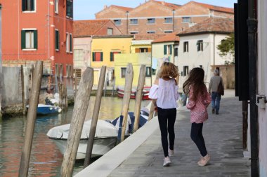 Genç kızlar Murano adasında turist olarak yürüyorlar, Veneto, İtalya