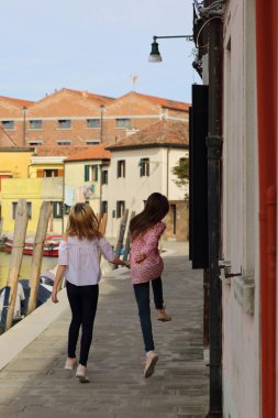 Genç kızlar Murano adasında turist olarak yürüyorlar, Veneto, İtalya