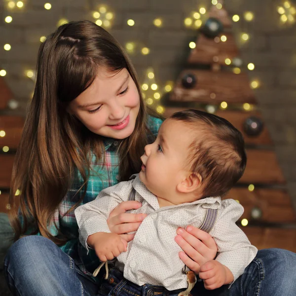 休日のテーマのクリスマス ツリーに姉妹と赤ちゃんの弟 — ストック写真