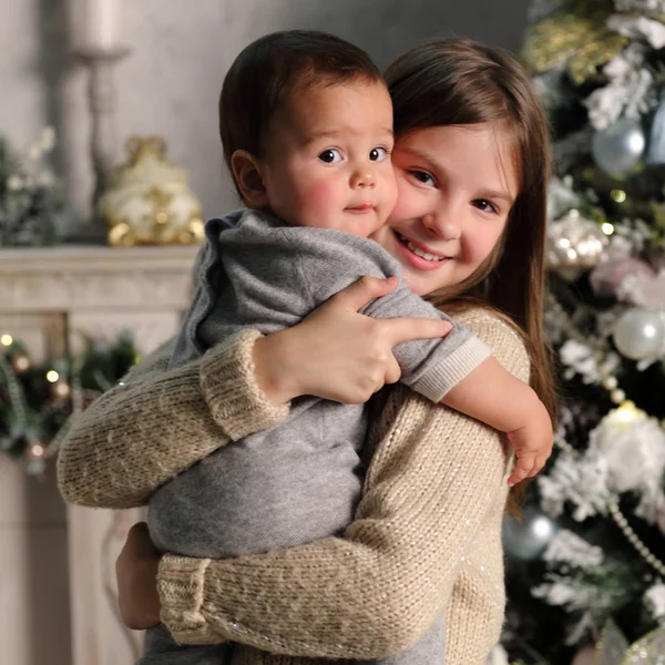 休日のテーマのクリスマス ツリーに姉妹と赤ちゃんの弟 — ストック写真