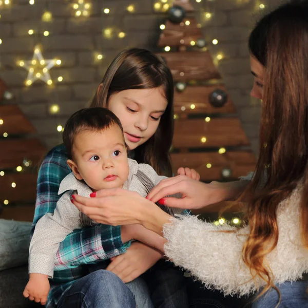 母亲与女儿和男婴在圣诞节树在假日主题 — 图库照片