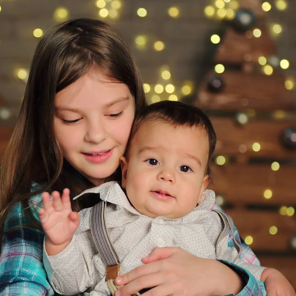 休日のテーマのクリスマス ツリーに姉妹と赤ちゃんの弟 — ストック写真