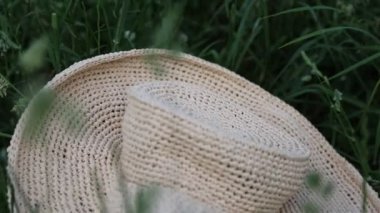Yazın yeşil çimenlikteki hasır şapkanın kısa görüntüleri. Seçili odak. Bulanık arkaplan. Bokeh.