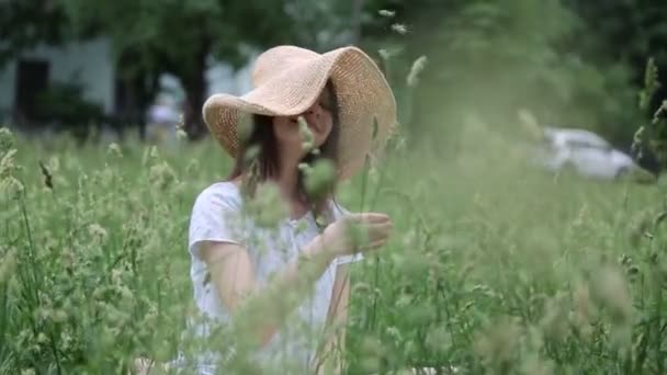 Hermosa Chica Caucásica Sombrero Paja Hierba Verde Verano Enfoque Seleccionado — Vídeo de stock