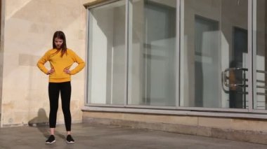 Genç ve güzel bir kız dışarıda sabah egzersizi yapıyor..