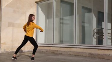 Genç kız klasik bale teknikleriyle prova yapmaya çalışıyor. Açık hava sınıfı.
