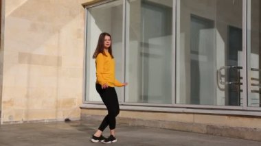 Genç kız klasik bale teknikleriyle prova yapmaya çalışıyor. Açık hava sınıfı.