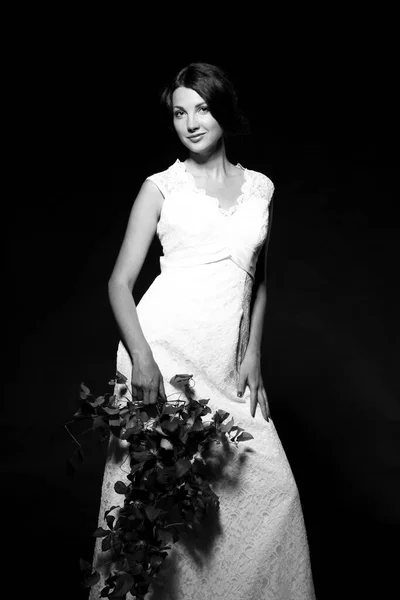 黒と白の背景に隔離された長い白いドレスを着た笑顔の若い女性のイメージ — ストック写真
