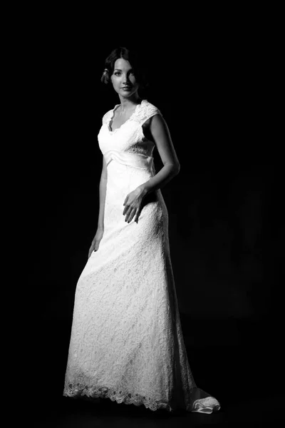 一个穿着黑色背景婚纱的年轻貌美的新娘的黑白画像 — 图库照片