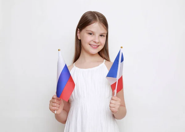拿着俄罗斯联邦和法国国旗的小女孩 — 图库照片