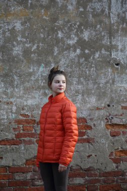 Kırmızı tuğlalı duvara karşı komik aktif genç gitl. Seçili odak.