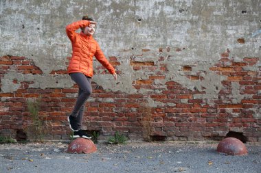 Kırmızı tuğlalı duvara karşı komik aktif genç gitl. Seçili odak.