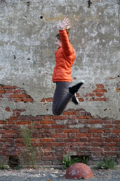 赤レンガの壁の屋外に対する面白いアクティブなティーンの女の子 選択されたフォーカス — ストック写真