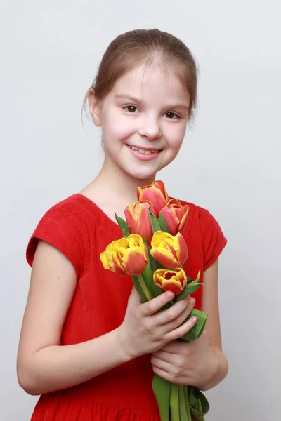 Urocza Dziewczynka Trzymająca Tulipany — Zdjęcie stockowe