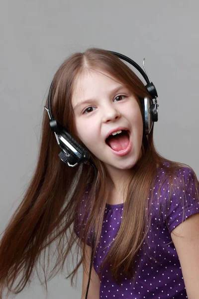 Fröhliches Kind Hört Musik Und Singt Stockbild