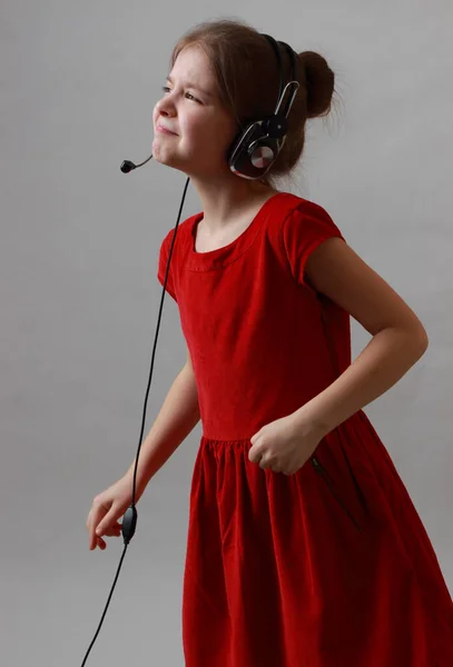Krásná Holčička Červených Šatech Poslouchat Hudbu Zpěv — Stock fotografie