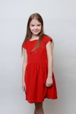 Duygusal çocuk kamerada poz veriyor ve dans ediyor. Kırmızı elbiseli küçük kız..