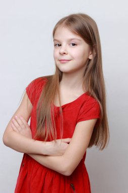 Duygusal çocuk kamerada poz veriyor ve dans ediyor. Kırmızı elbiseli küçük kız..