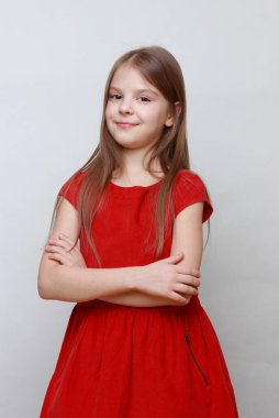 Zarif duygusal çocuk kamerada poz veriyor ve dans ediyor. Kırmızı elbiseli küçük kız..