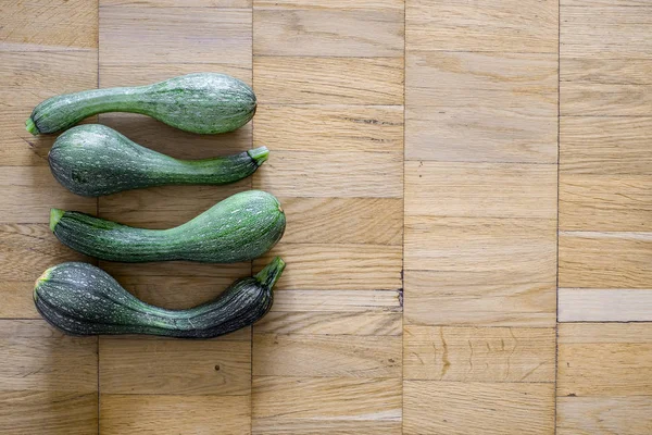 Bir hafif kahverengi ahşap uçakta dört yeşil kabak