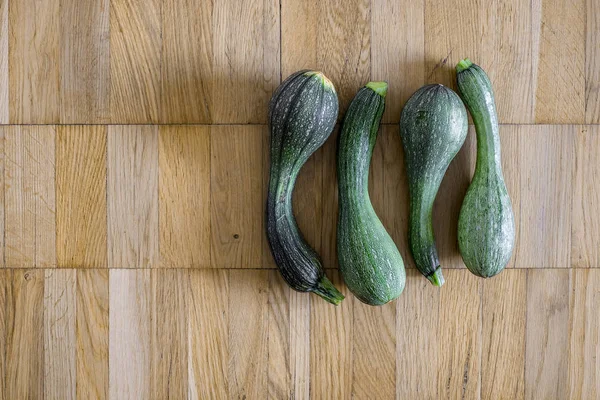 Bir hafif kahverengi ahşap uçakta dört yeşil kabak