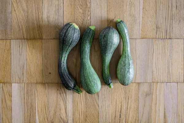 Bir hafif kahverengi ahşap uçakta dört yeşil kabak