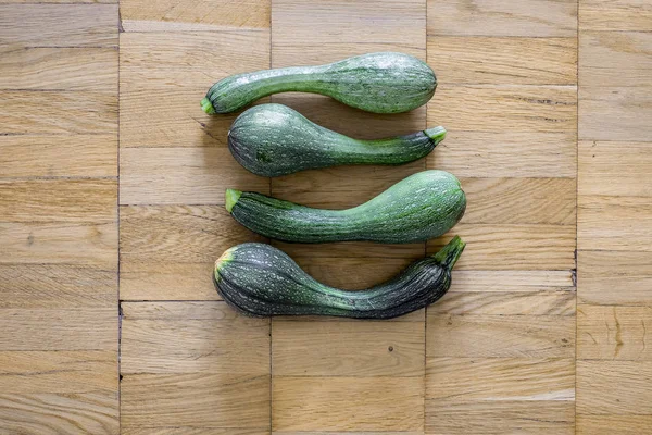 Bir hafif kahverengi ahşap uçakta dört yeşil kabak