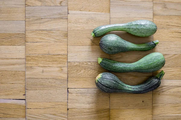 Bir hafif kahverengi ahşap uçakta dört yeşil kabak