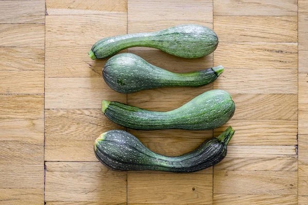 Bir hafif kahverengi ahşap uçakta dört yeşil kabak