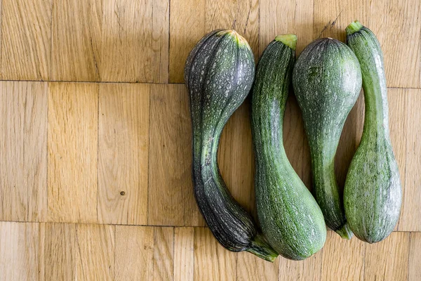 Bir hafif kahverengi ahşap uçakta dört yeşil kabak