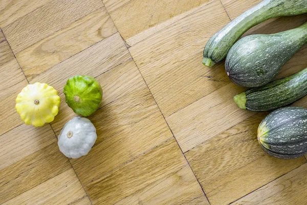 Küçük tarak squashes hafif kahverengi ahşap zemin üzerinde ile dört yeşil kabak