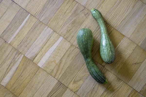 Bir hafif kahverengi ahşap uçakta iki yeşil kabak