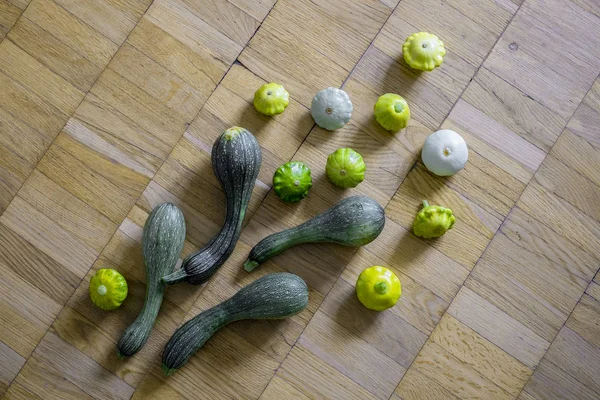 Küçük tarak squashes hafif kahverengi ahşap zemin üzerinde ile dört yeşil kabak