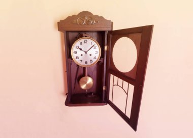 Bir sıcak, pastel arka planda açılan ön cam ile antika, ahşap duvar saati 