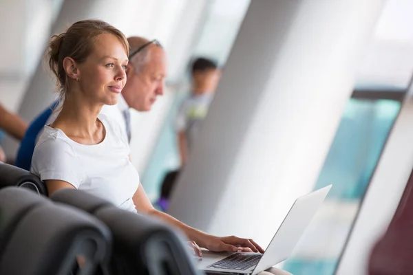 空港で若い女性の乗客 搭乗案内を待っている間彼女のラップトップ コンピューターを使用して トーン色イメージ 浅い被写し界深度 — ストック写真